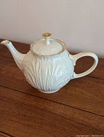 Side view of Lenox Cottage Leaf Collection teapot on wooden surface highlighting embossed leaf pattern and overall shape.