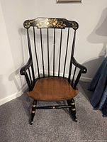 Front view of Nichols & Stone wooden rocking chair with Gold Harvest decoration, showing solid wooden seat and backrest with spindles.