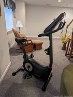 Side view of black Schwinn stationary exercise bike showing adjustable padded seat, pedals, and overall frame design.