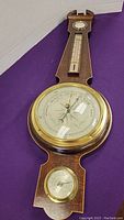 Full view of the wood and brass barometer showing barometer, thermometer, and hygrometer