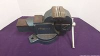 Front and side views of the heavy-duty bench clamp showing its size, build, and rotating base feature.