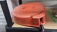 Full view of the orange plastic reel from the top showing the carry handle and overall reel shape.