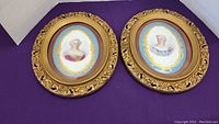 Two oval framed painted pottery portraits featuring Victorian ladies in detailed period attire, with gilded ornate frames, shown together on purple background.