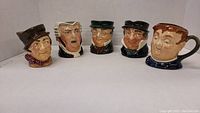 Photo of all five Royal Doulton Toby jugs lined up showing all characters
