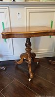 Full front view showing scalloped rectangular top and carved pedestal base