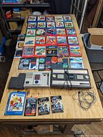 Overhead view of both consoles, controllers, game cartridges in boxes and loose overlays