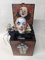 Front view of the jack in the box showing the clown head emerging from a decorated container featuring clown illustrations.