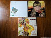 Top-down view of three Joni Mitchell albums: 'Ladies of the Canyon,' 'Clouds,' and self-titled, showing cover art