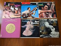Six Indian classical music vinyl album covers featuring Ravi Shankar and Ali Akbar Khan displayed in two rows on wooden floor.