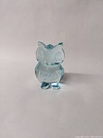 Front side view of the light blue glass owl figurine showing clear facial features and chest pattern.