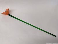 Full view of the entire 18-inch Murano glass flower with orange petals and green stem against a white background.