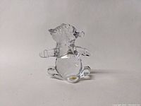Clear crystal penguin figurine viewed from the front, showing the head and flipper details