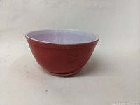 Side view of the Pyrex bowl showing its burnt orange exterior and white interior.