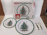 Two ceramic plates side-by-side with two brass hardware pieces and original box behind them.