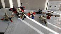 Six Transformers jet/aircraft figures lined up in sunlight