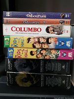 Seven DVD boxsets stacked, showing titles: The Osbournes Season 1 and 2, Colombo Complete First Season, Kids in the Hall Seasons 3 and 5, James Bond Ultimate Edition Volumes 1 and 4