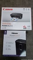 Photo showing original boxed Canon PIXMA MG2525 printer and Fellowes PowerShred shredder together.
