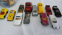 Twelve vintage Matchbox die-cast car models arranged on a white surface, showing all sides of the models.