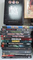 Box set and stack of DVD titles including The Pink Panther collector's set, Tank Girl, Dead Man, Evil Dead, among others.