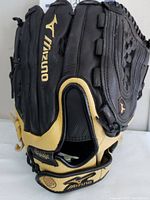 Side view of black and yellow Mizuno baseball glove with 'Flex Bridge' label and Mizuno logo on the wrist strap.