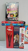 Photo showing stacked DVD box sets including Drawn Together Season 3 Uncensored on top, Drawn Together Seasons 1 and 2, Please Teacher, Rune Soldier, Love Hina, Ren and Stimpy uncut collections.