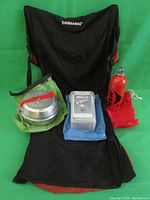 ThermaRest camping chair with MSR fuel bottle, camp pot, and Mirro utensil case arranged on the chair seat.