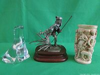 Photo showing all three items: pewter Seminole sculpture, clear crystal seal figurine, Roman scene candle holder vase arranged side by side.