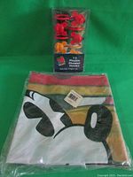 Disney Mickey Mouse shower curtain folded, packed in clear plastic with barcode visible, showing part of Mickey Mouse face and red, yellow stripes