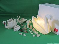 All swan figurines and night light visible with green backdrop