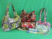 All Vera Bradley purses in lot displayed together: three shoulder bags, one crossbody with wallet, one lunch bag with small pouch.
