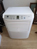 Front angled view of white Zenith ZD300YO dehumidifier showing control panel and grille.