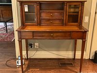 Full front view of the desk showing lower drawer, pull-out writing surface, and upper cabinetry