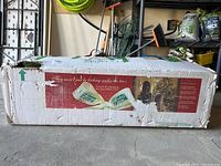 Full view of original cardboard packaging showing front panel graphics and green straps