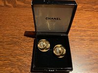 Open black velvet Chanel box displaying both earrings