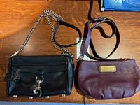 Two leather crossbody bags displayed on wooden surface, showing both front views and straps