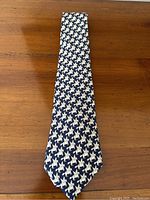 Full front view of navy tie laid flat on wooden surface