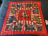 Full scarf laid flat showing red and white stripes with knight motifs