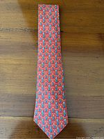 Full length of tie laid flat on wood surface showing overall shape and pattern