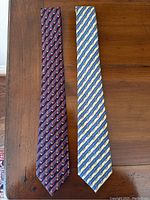 Full-length front view of both ties side by side on wooden surface