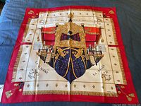 Full laydown view of scarf showing entire red border and central design