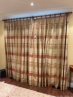 Full view of silk drapery panels hanging on wooden rod