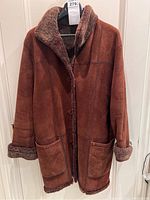 Front view of women's brown shearling jacket on a hanger