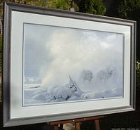 Framed large print depicting wolves in snowy Yellowstone scenery with visible silver wood frame and triple matting.