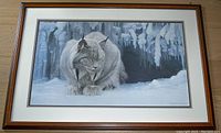 Front view of the framed print showing the lynx in snow with icy background and signature at bottom right.