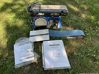 Full view of Mastercraft Belt and Disc Sander including sanding belt, disc, and owner's manual in plastic sleeve.