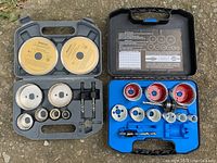 Two Mastercraft hole saw cases open, showing multiple hole saws and accessories inside, placed on the ground.