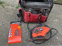 Black & Decker Mouse detail sander, sandpaper pack and tool bag on concrete surface