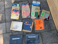 All sandpaper sheets and two Mastercraft organizers displayed on pavement