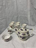 Arthur Wood teapot with floral design, Royal Albert cream and sugar, and five coffee mugs with floral patterns.