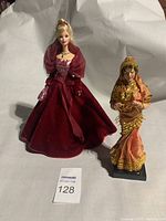 Barbie doll in red evening gown with smaller ethnic doll beside her